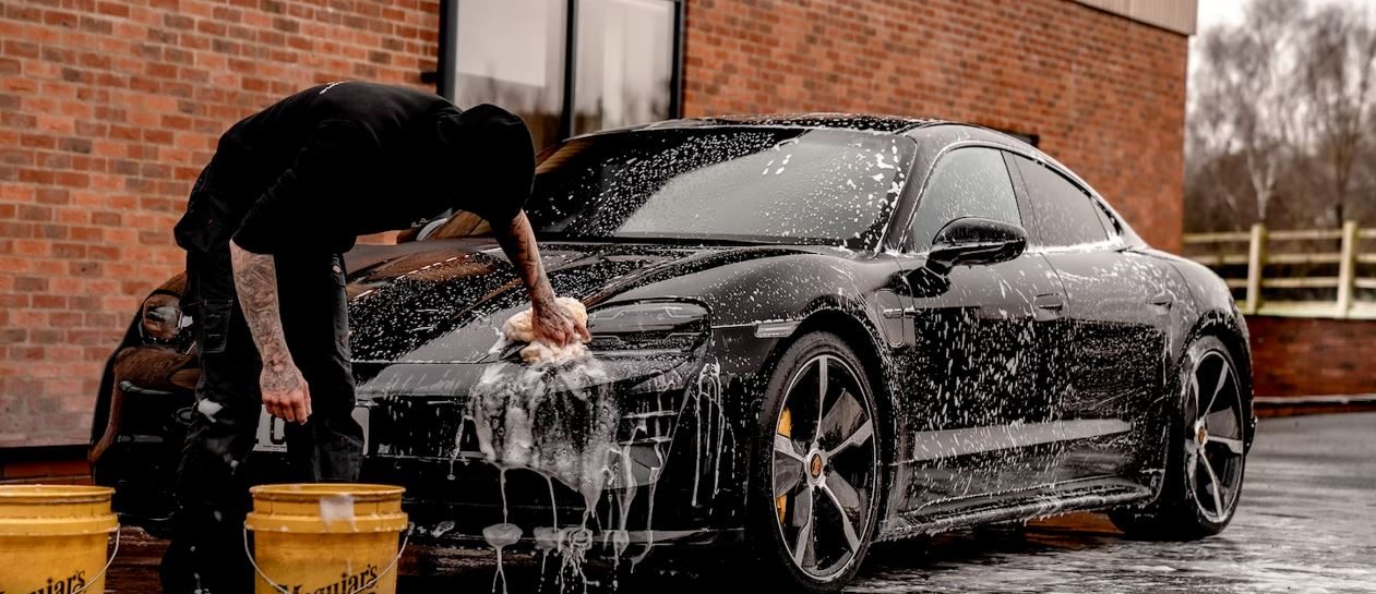 man-doing-water-splash-on-black-coupe