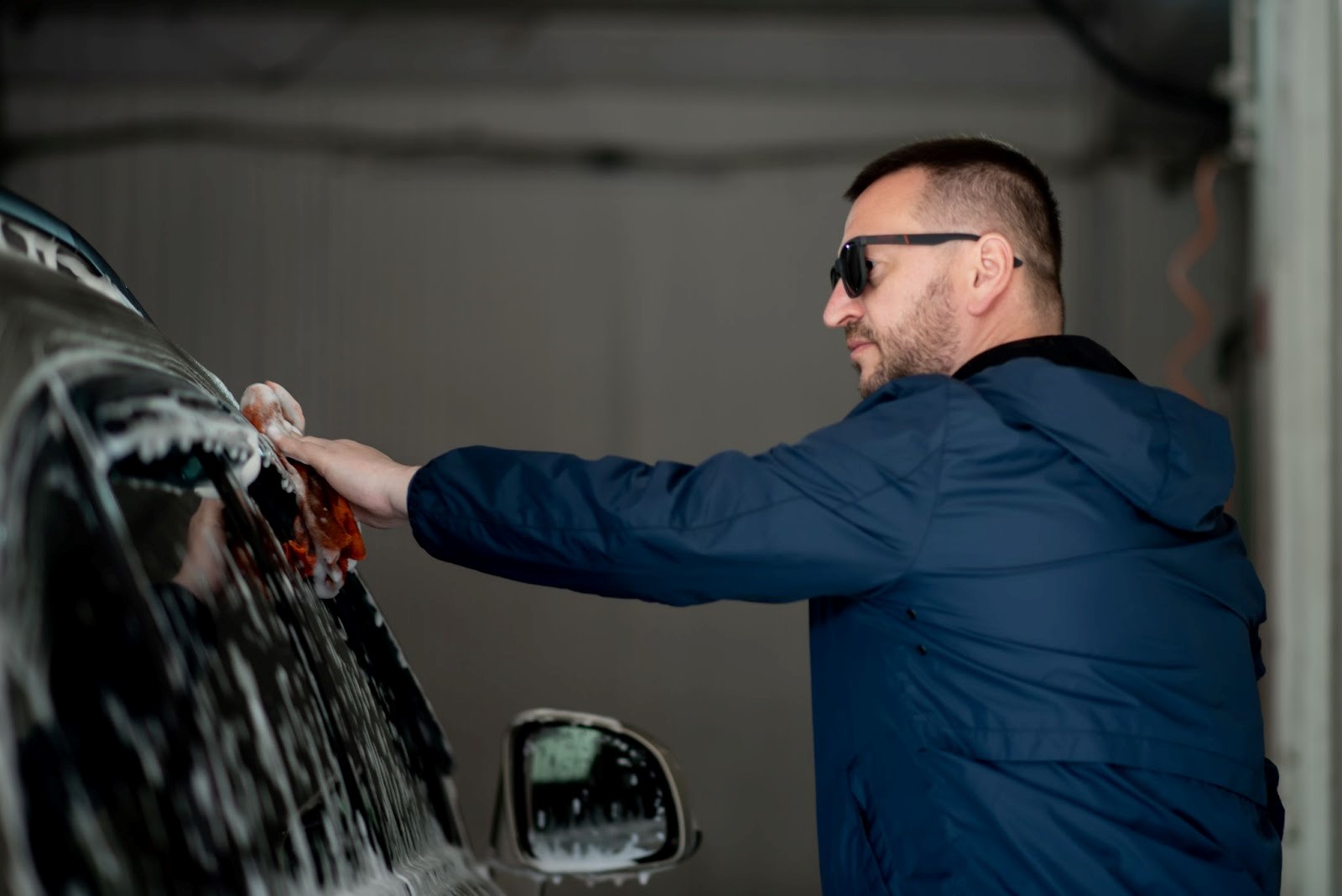 man-washes-cars-at-car-service-center