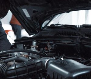 man-in-grey-shirt-checking-a-black-car-engine