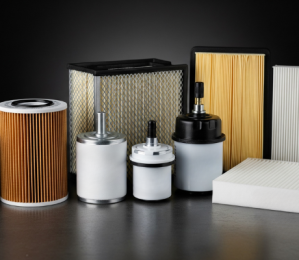 A collection of various new car filters, including cylindrical oil filters, rectangular air filters, and cabin filters, arranged on a dark, reflective surface against a black background.