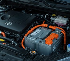 Close-up of a hybrid car's engine bay showing the EV car battery and internal combustion engine.